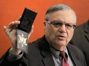 FILE - In this Dec. 21, 2011 file photo, Maricopa County Sheriff Joe Arpaio shows his badge as he holds a ceremony where 92 of his immigration jail officers, who lost their federal power to check whether inmates are in the county illegally, turn in their credentials after federal officials pulled the Sheriff's office immigration enforcement powers in Phoenix. Arpaio is running again to get back his old job as sheriff of metro Phoenix. His 24 years as sheriff were defined by a series of tough-on-crime tactics and legal problems that cost taxpayers millions of dollars. (AP Photo/Ross D. Franklin, File)