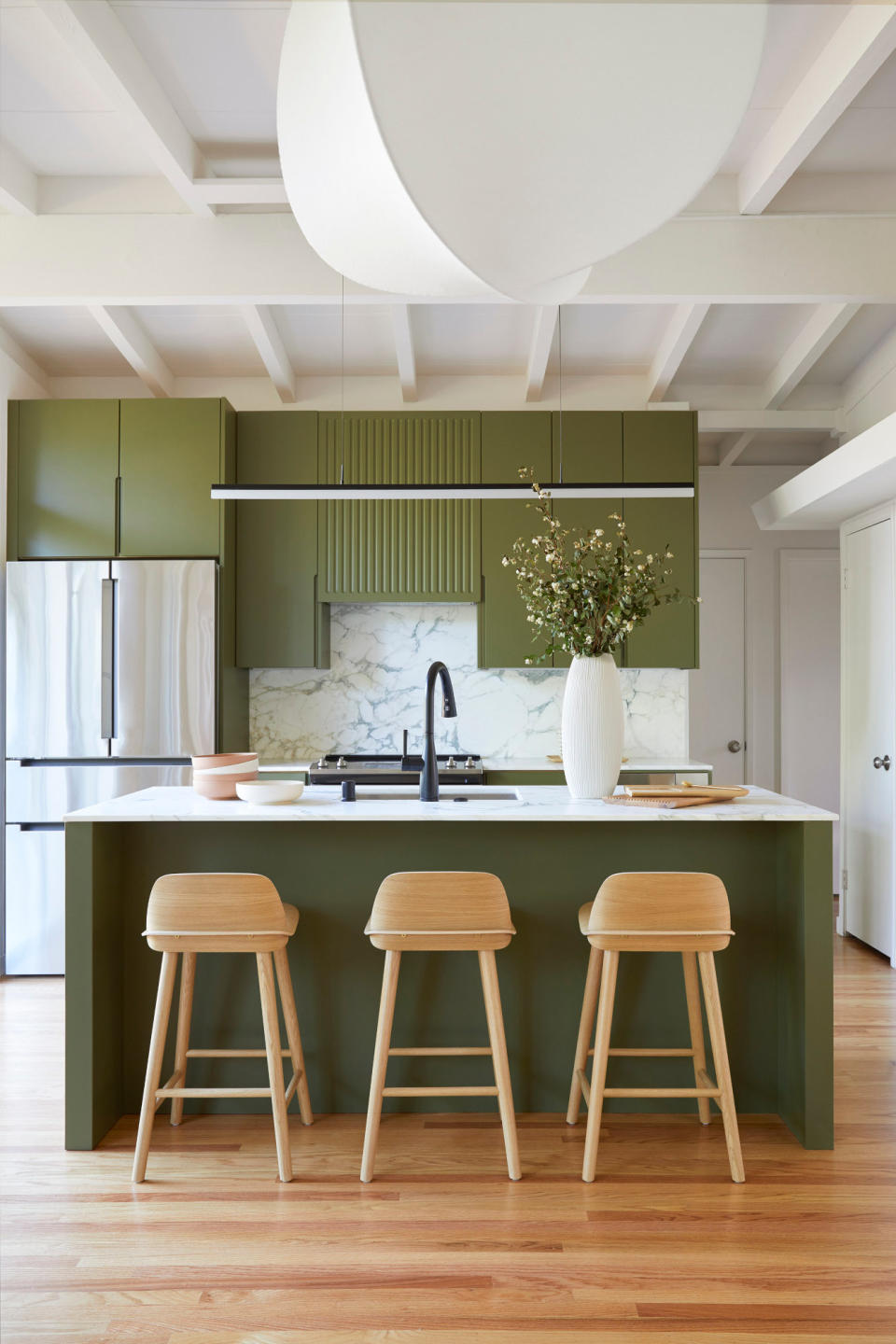 Minimalist green kitchen with wood bar stools