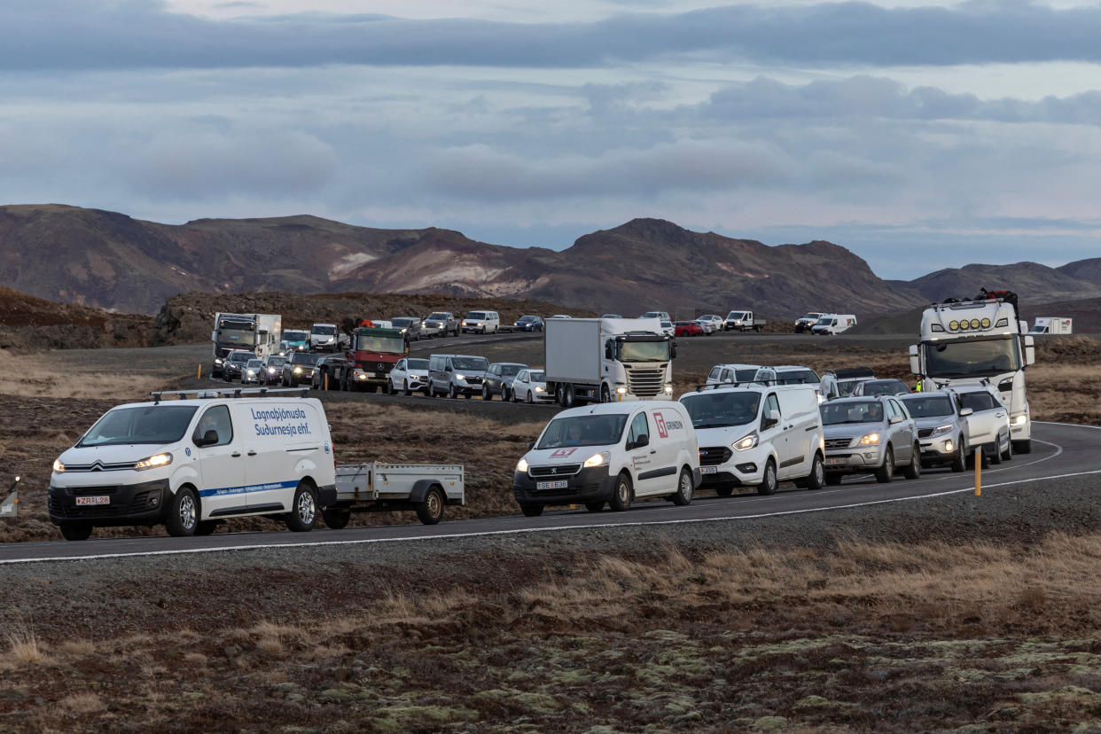 A line of cars at a standstill along a winding highway as residents wait to get access to their homes in the fishing town of Grindavik.
