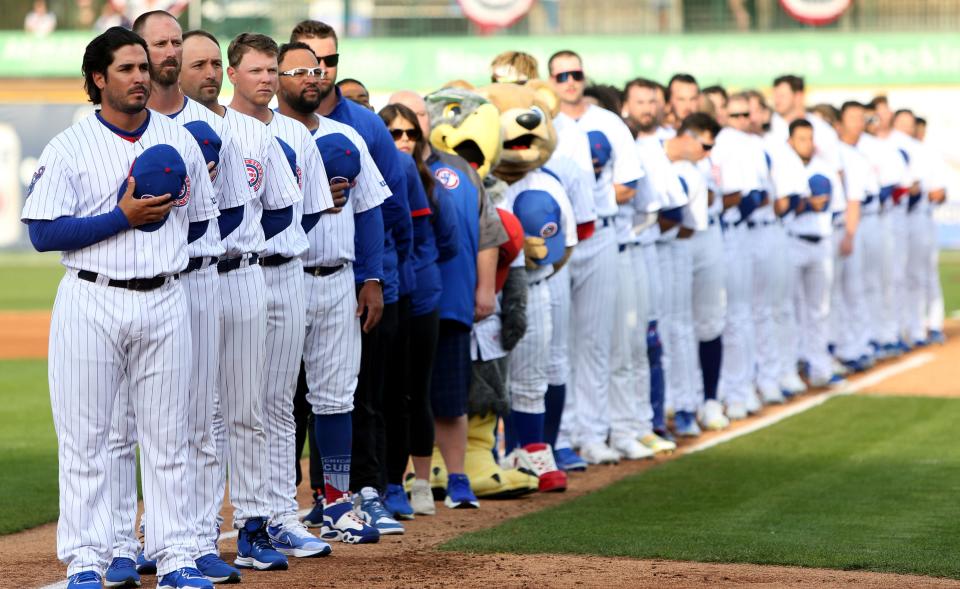 The South Bend Cubs team stands to honor the American Flag Tuesday, April 11, 2023, at Four Winds Field for the 2023 season home opening baseball game against Beloit.