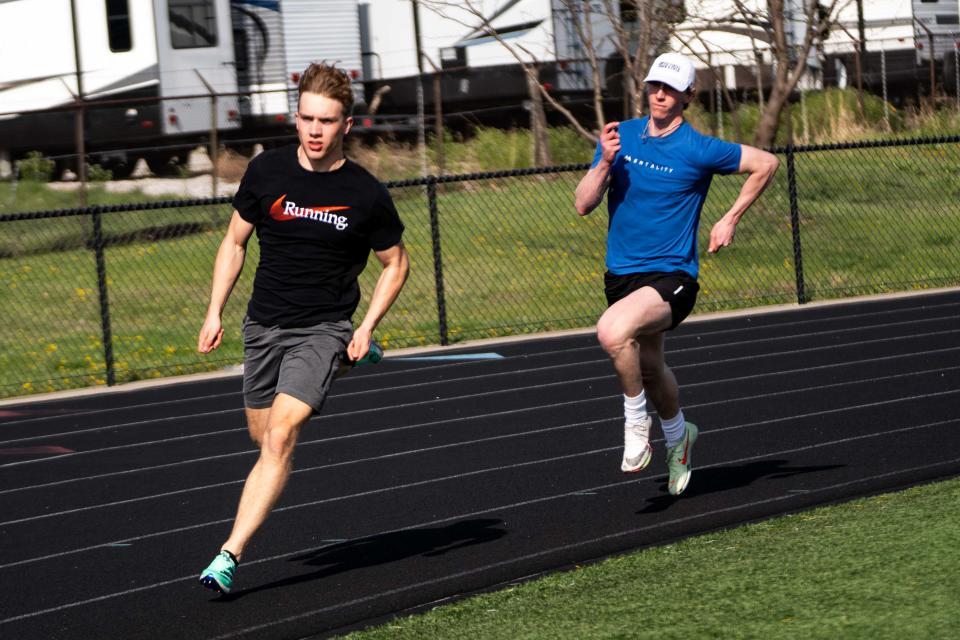 Ankeny's Logan Fairchild and Tyler Sickerson run a 200 during practice April 17 at Ankeny High School.