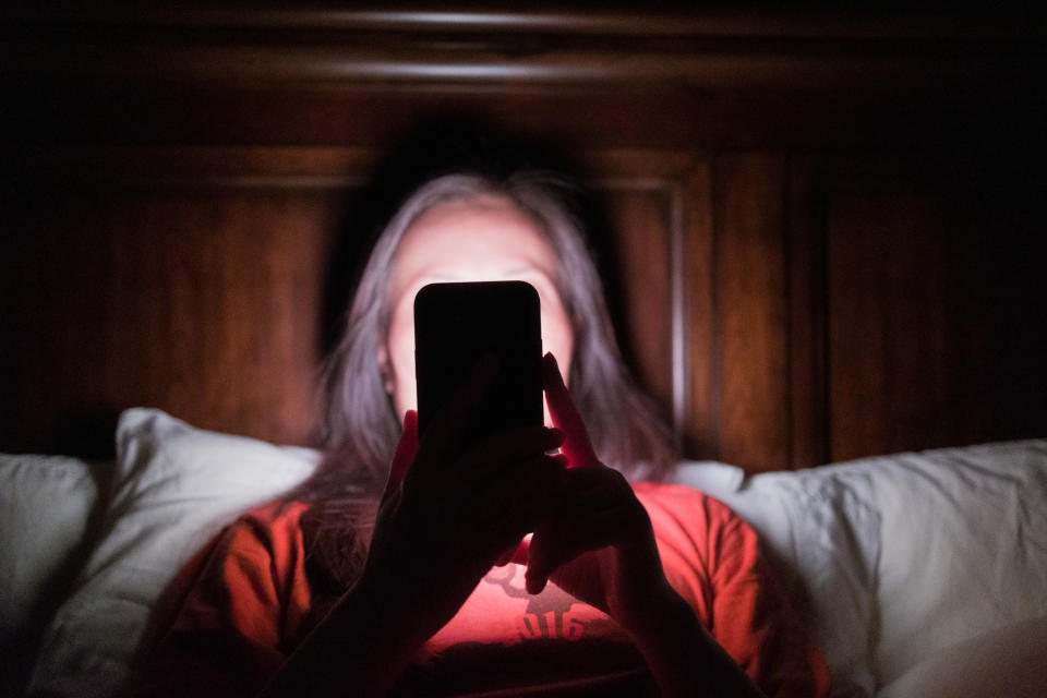 woman on her phone while in bed