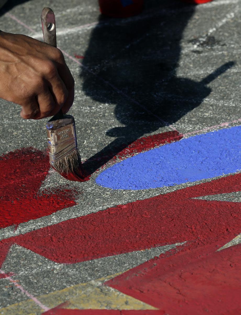 Agnaldo Eduardo Kobra, of Brazil, works on his 3D pavement art during the Sarasota Chalk Festival Wednesday, Oct. 31, 2012, in Sarasota, Fla. The annual festival begins this week and runs through Nov. 6.(AP Photo/Chris O'Meara)