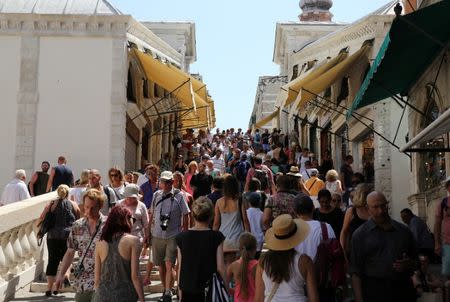 Tourists walks on Rialto bridge in Venice, Italy, August 3, 2017. Picture taken on August 3, 2017. REUTERS/Stefano Rellandini