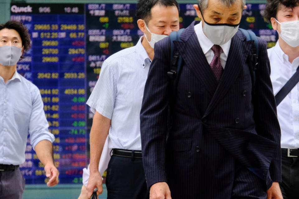 Japanese businessmen walk past a screen displaying the Nikkei share average and world stock indexes outside a Tokyo brokerage on Sept. 6, 2021<span class="copyright">James Matsumoto/SOPA Images/LightRocket via Getty Images</span>