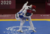 Kimia Alizadeh Zonoozi, Refugee Olympic Team, right, is attacked by Britain's Jade Jones during the taekwondo women's 57kg match at the 2020 Summer Olympics, Sunday, July 25, 2021, in Tokyo, Japan. (AP Photo/Themba Hadebe)