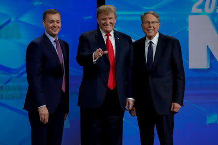 FILE PHOTO: U.S. President Donald Trump is greeted by Chris Cox (L) and Wayne LaPierre (R), executive vice president and CEO of the National Rifle Association (NRA), at the NRA annual meeting in Indianapolis, Indiana, U.S., April 26, 2019. REUTERS/Bryan Woolston/File Photo