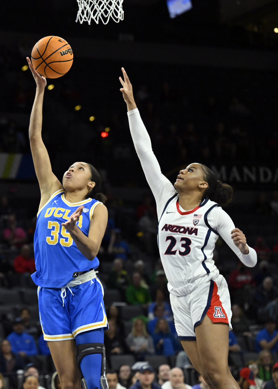 UCLA guard Camryn Brown (35) shoots against Arizona guard Lauren Fields during the first half of an NCAA college basketball game in the quarterfinal round of the Pac-12 women's tournament Thursday, March 2, 2023, in Las Vegas. (AP Photo/David Becker)