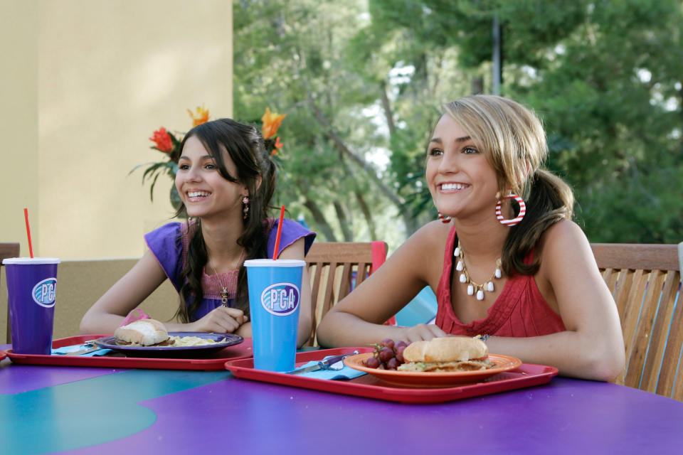 Lola and Zoey sitting at a table with trays of food in front of them