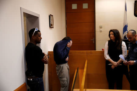 U.S.-Israeli teen (2ndL) arrested in Israel on suspicion of making bomb threats against Jewish community centres in the United States, Australia and New Zealand over the past three months, is seen before the start of a remand hearing at Magistrate's Court in Rishon Lezion, Israel March 23, 2017. REUTERS/Baz Ratner