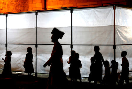 An Ultra-Orthodox Jewish man walks next to a synagogue during the celebrations of Simchat Torah at the Mea Shearim neighbourhood of Jerusalem October 1, 2018. REUTERS/Ronen Zvulun