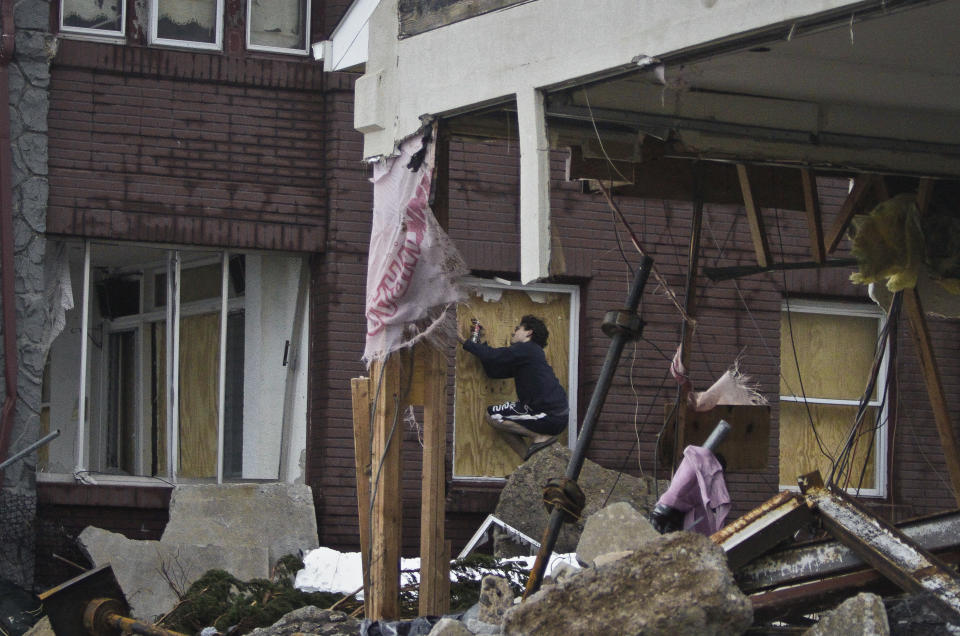 Marcus Konner, 22, boards his home in the aftermath of a storm surge from Hurricane Sandy, Tuesday, Oct. 30, 2012, in Coney Island's Sea Gate community in New York. (AP Photo/Bebeto Matthews)