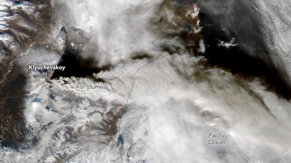 A satellite image of a large eruption plume stretching across Russia and the Pacific Ocean