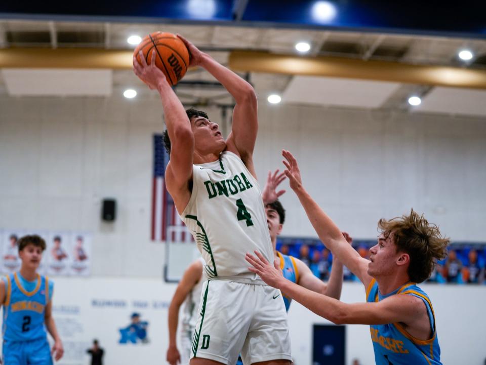 Dinuba's Javier Torres drives passed Monache's Ty Baxter duringThe 72nd annual Polly Wilhelmsen Invitational Basketball Tournament first-round game.