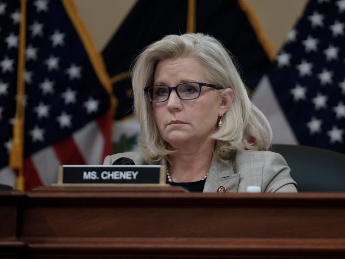 Republican Rep. Liz Cheney of Wyoming, a nameplate identifying her right in front and a pair of American flags at her back, participates in a January 6 committee meeting on Capitol Hill.