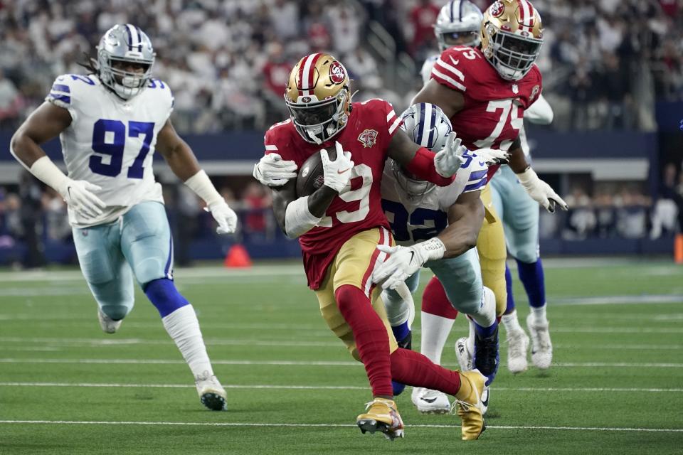 FILE -San Francisco 49ers wide receiver Deebo Samuel (19) attempts to escape the grasp of Dallas Cowboys defensive end Dorance Armstrong (92) as defensive tackle Osa Odighizuwa (97) moves in to help make the tackle in the first half of an NFL wild-card playoff football game in Arlington, Texas, Sunday, Jan. 16, 2022. The 49ers-Cowboys playoff history is a rich one from back-to-back conference title games in the early 1970s, the iconic “Catch” in the 1981 season and then the heated rivalry in the 1990s when the Cowboys won the first two meetings on the way to Super Bowl titles and then the Niners took the third game.(AP Photo/Tony Gutierrez, File)