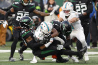 New York Jets linebacker C.J. Mosley (57) and cornerback Sauce Gardner (1) tackle Miami Dolphins wide receiver Jaylen Waddle (17) during the second quarter of an NFL football game, Friday, Nov. 24, 2023, in East Rutherford, N.J. (AP Photo/Noah K. Murray)