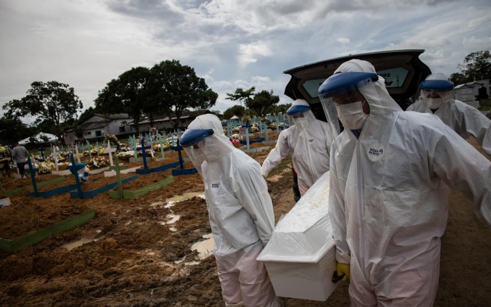 Workers bury a person who died with covid-19, in the Nossa Senhora Aparecida public cemetery in Manaus, Amazona - Raphael Alves/EPA-EFE/Shutterstock