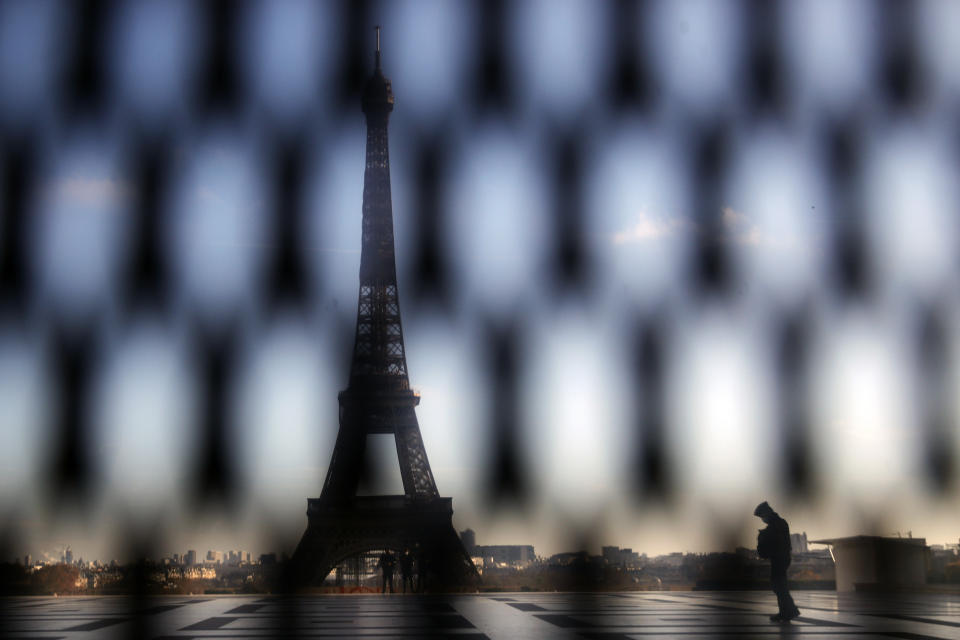 A policeman is pictured through a security fence during a protest against bill on police images, in Paris, Saturday, Nov. 21, 2020. Thousands of people took to the streets in Paris and other French cities Saturday to protest a proposed security law they say would impinge on freedom of information and media rights. The Eiffel tower is seen background. (AP Photo/Christophe Ena)