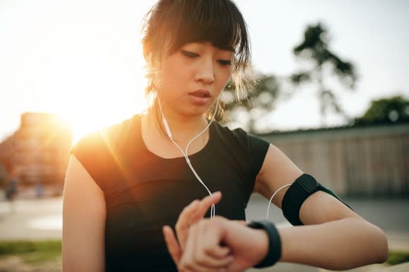 A woman checks her fitness tracker.