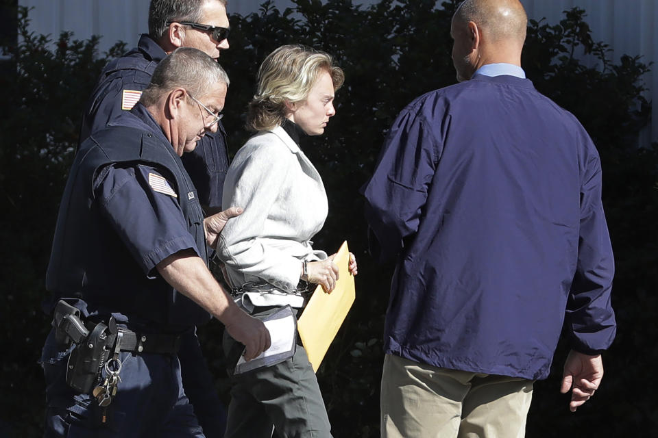 Michelle Carter, center, is escorted to a parole hearing, Thursday, Sept. 19, 2019, in Natick, Mass. Carter, who was sentenced to 15 months in jail for urging her suicidal boyfriend via text messages to take his own life, is asking for early release. (AP Photo/Steven Senne)