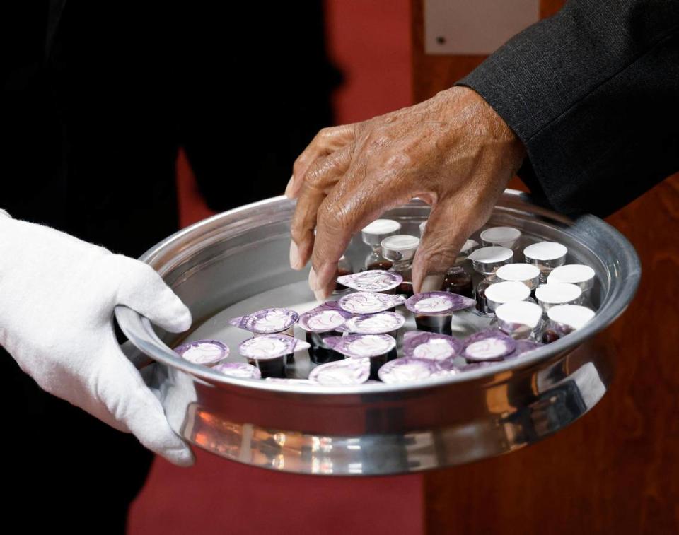 Members of the congregation take items for Communion when entering during morning services at Shiloh Missionary Baptist Church.