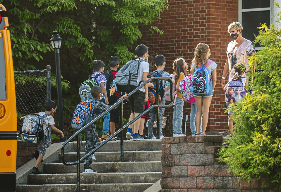 Students arrive masked to Memorial Elementary School, Tuesday, Aug. 24, 2021, in Bethel Park, Pa., a Pittsburgh suburb. In a heated school board meeting the previous evening, the Bethel Park School District voted to amend the district's health and safety plan and require all students, staff and visitors to wear masks inside the district's schools. (Andrew Rush/Pittsburgh Post-Gazette via AP)