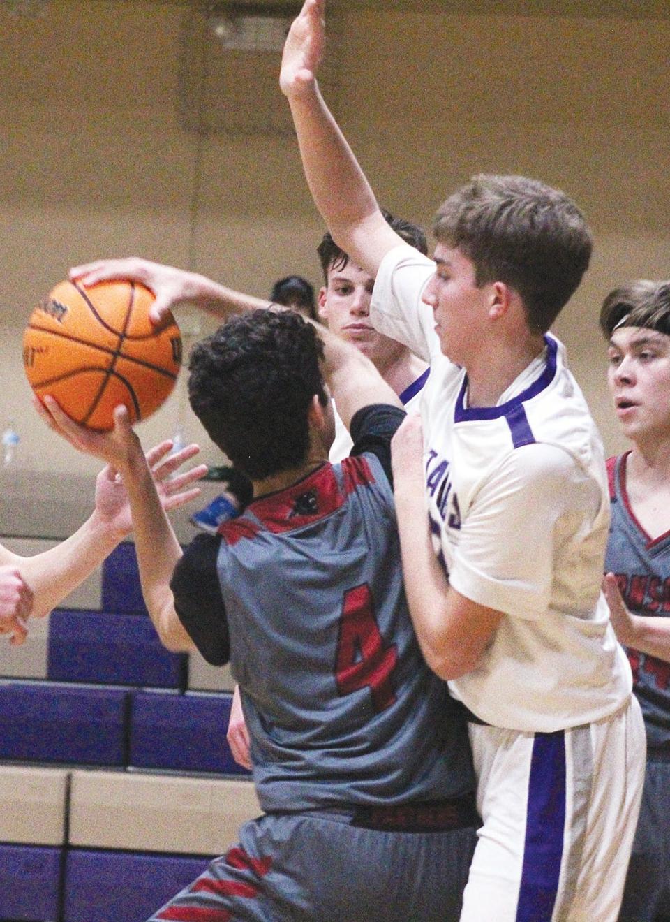 Wesleyan Christian School's Tyrel Cloud, right, looms over an opposing shooter during varsity boys basketball action in a recent season.