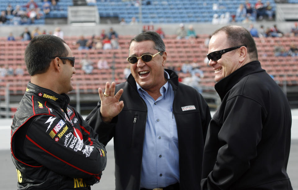 FILE - In this Feb. 11, 2007, file photo, NASCAR driver Juan Pablo Montoya, left, of Colombia, shares a laugh with co-owners Felix Sabates, center, and Chip Ganassi as they wait for qualifying for the Daytona 500 auto race, at Daytona International Speedway in Daytona Beach, Fla. Felix Sabates is leaving NASCAR after 30 years as a team owner. The Cuban refugee came to the United States at 15 and built a lucrative business that allowed him to enter NASCAR in 1989. (AP Photo/Glenn Smith, File)