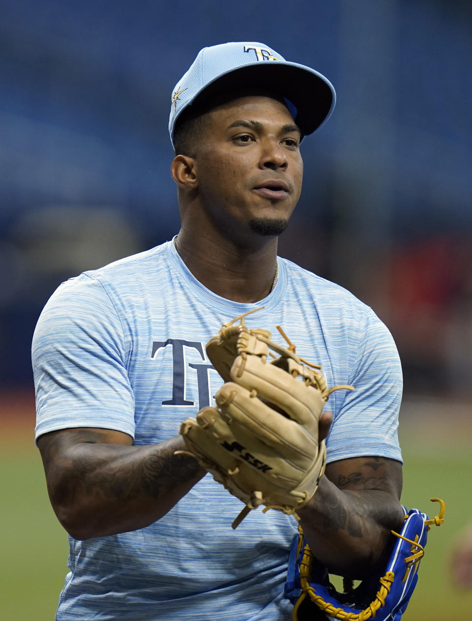 Tampa Bay Rays third baseman Wander Franco tries on gloves before a baseball game against the Boston Red Sox Tuesday, June 22, 2021, in St. Petersburg, Fla. The Rays called up Franco from their Class AAA Durham team. (AP Photo/Chris O'Meara)