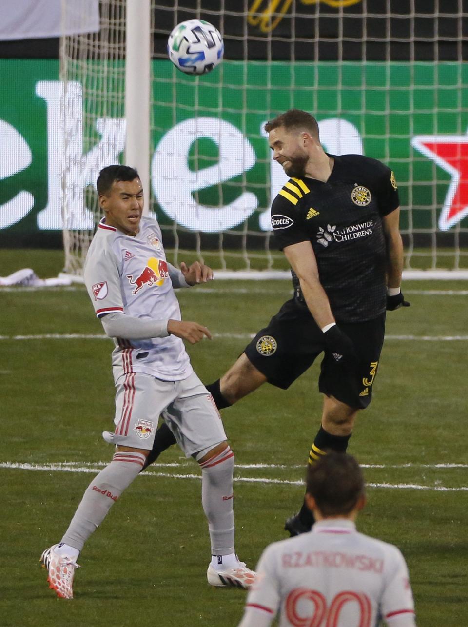 Crew defender Josh Williams heads a ball over New York Red Bulls midfielder Kaku in 2020.