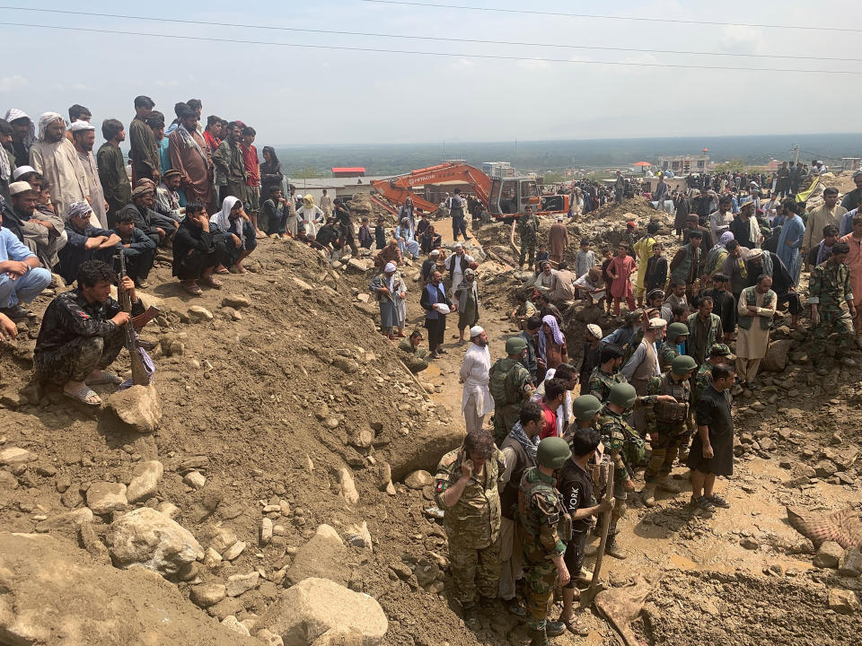 Soldiers and locals search for victims in a mudslide following heavy flooding in the Parwan province, north of Kabul, Afghanistan, Wednesday, Aug. 26, 2020. Heavy flooding in northern Afghanistan has killed and injured dozens of people officials said Wednesday. (AP Photo/Rahmat Gul)