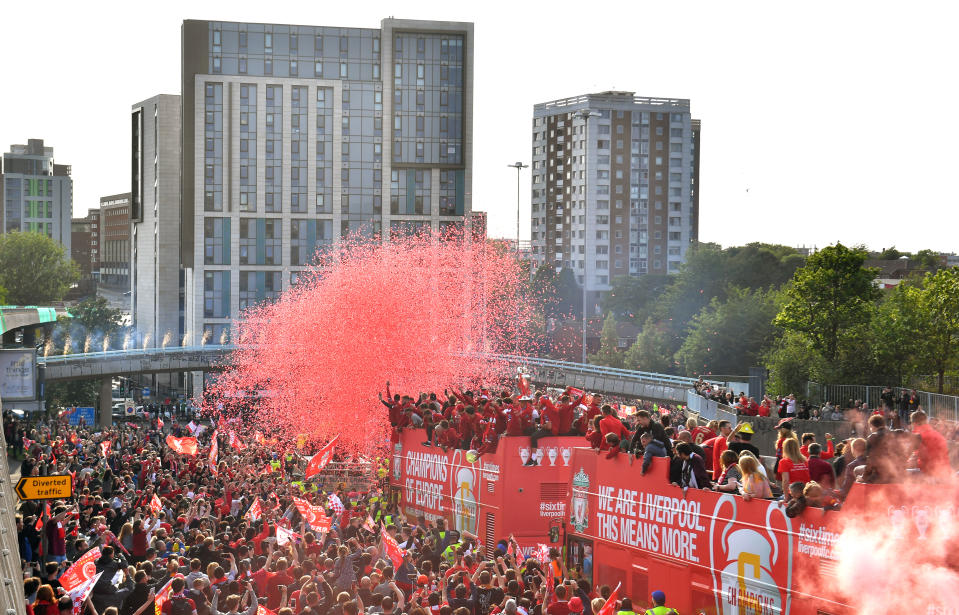 Fireworks are set off as the Liverpool bus passes through the crowds during the Champions League Winners Parade in Liverpool.