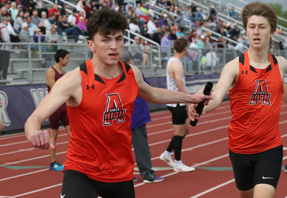 Ames runners Charlie Bennett (right) and Erik Anderson exchange the baton during tje boys 4x800-meter relay at the Class 4A state qualifying track and field meet on Thursday in Norwalk, Iowa. Bennett helped the Ames boys place fourth in both the 4x800 and distance medley at the qualifying meet.