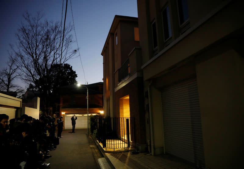 Journalist stand outside the Tokyo residence of former Nissan chairman Carlos Ghosn, while prosecutors raid the house, in Tokyo