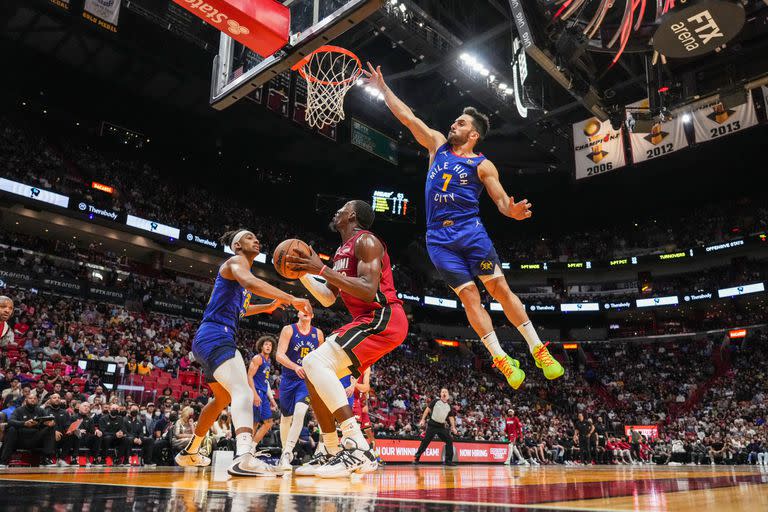 Facundo Campazzo salta para intentar bloquear el disparo de Bam Adebayo, de Miami Heat