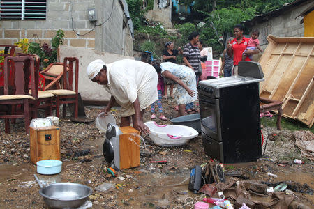 A woman washes her belongings affected by the overflow of the Soco River in the aftermath of Hurricane Maria in El Seibo, Dominican Republic, September 22, 2017. REUTERS/Ricardo Rojas