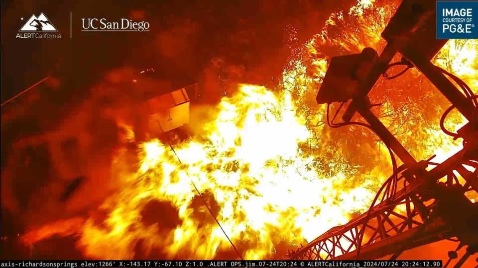 Flames are seen at the base of a communications tower along Richardson Springs Road and Mud Creek before images from the PG&E wildfire camera stopped transmitting Wednesday, July 24, 2024. The Park Fire has burned more than 45,000 acres since sparking Wednesday afternoon.