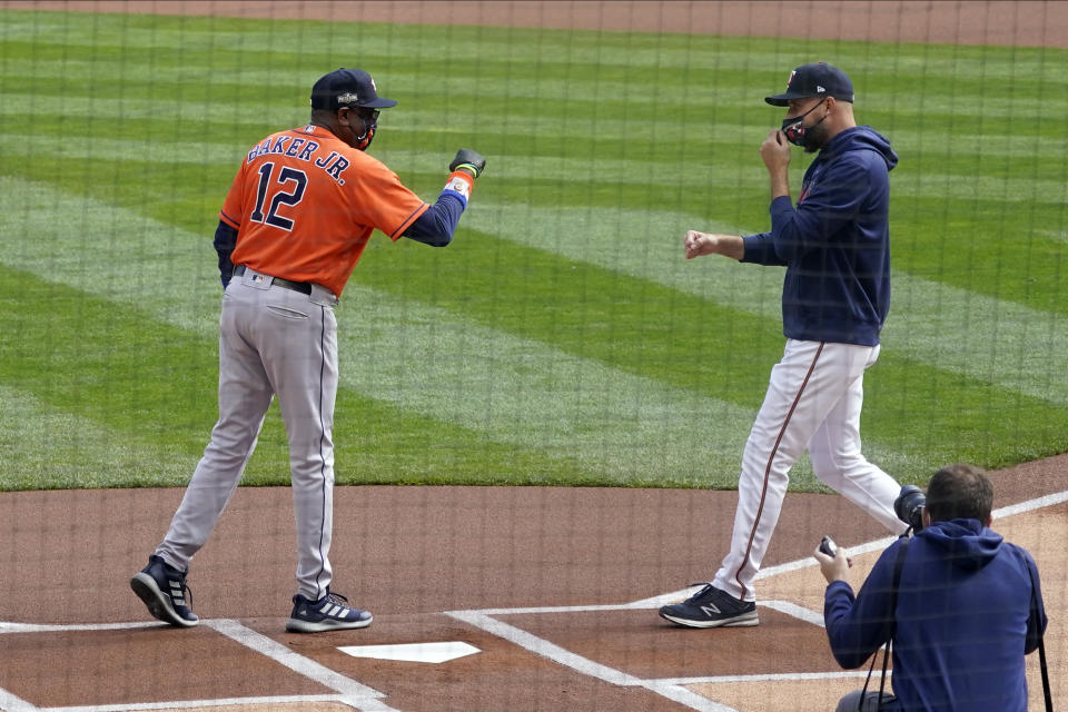 Minnesota Twins manager Rocco Baldelli, right, and Houston Astros manager Dusty Baker, Jr. greet each other before the first inning of an American League wild-card series baseball game Tuesday, Sept 29, 2020, in Minneapolis. (AP Photo/Jim Mone)