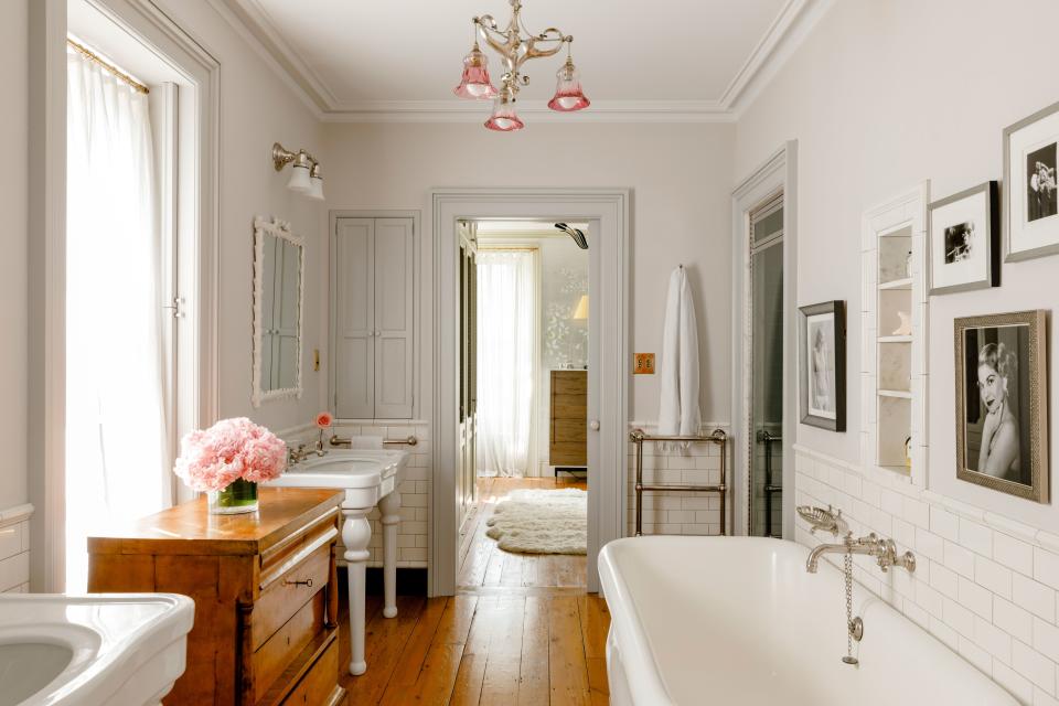 A pocket door with textured pink glass slides open to connect the closet with the master bathroom. “I spend a lot of time here,” says Tyler. “I always take big bubble baths. I read in the tub. Watch movies in the tub.” Framed photos include one of her grandmother, etiquette expert Dorothea Johnson, and one of her mother—model, musician, and author Bebe Buell. Others are stills from the film Stealing Beauty, which stars Tyler. “These are of me dressed as my character Lucy’s mother,” explains Tyler. “I have a blonde, short wig on, and I’m in a dress, smoking a long cigarette. A woman from another time.” Tyler and her architect Ben Pentreath found this vintage chandelier on one of their many visits to the famed Alfie’s Antique Market in London.