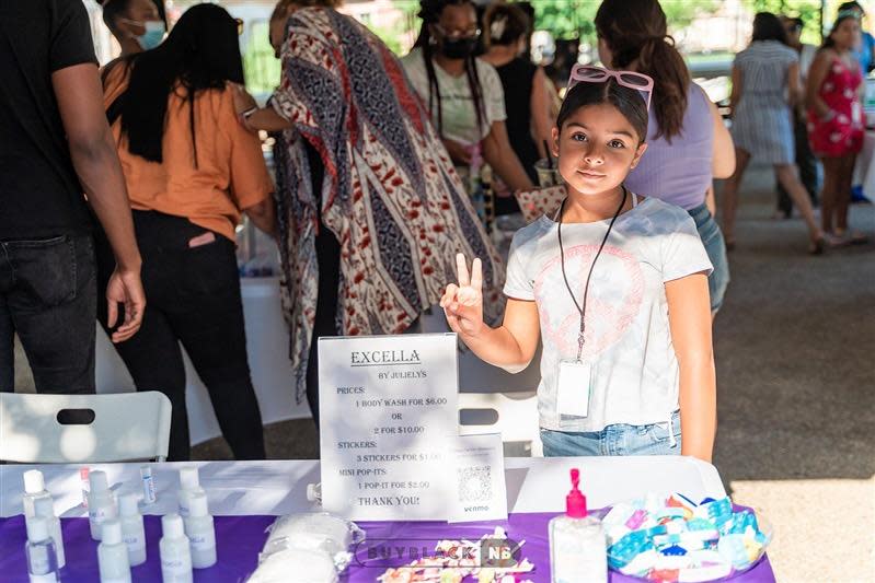 Julielys Monteiro, 9, stands with her products, including homemade body wash and chapstick, at the Dream Makers Market on Thursday, July 14, at Wing's Court in downtown New Bedford, as part of the annual Kids Rule AHA! Night.
