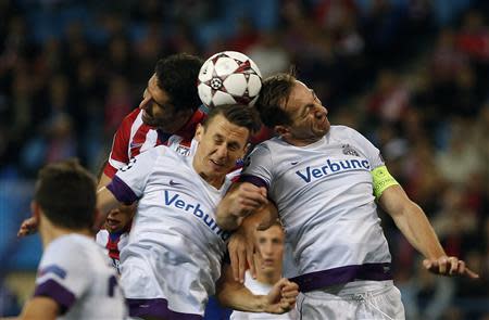 Atletico Madrid's Raul Garcia (L) fights to head the ball with Austria Vienna's Florian Mader (C) and Manuel Ortlechner during their Champions League Group G soccer match at Vicente Calderon stadium in Madrid November 6, 2013. REUTERS/Susana Vera