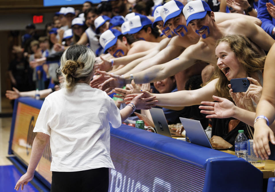 Samantha DiMartino, 10, gets high-fives from fans in the Duke student section after being honored as a part of the Scheyer Family Kid Captains Program, which recognizes patients and families of Duke Children's Hospital, during a timeout at an NCAA college basketball game between Duke and Louisville in Durham, N.C., Wednesday, Feb. 28, 2024. (AP Photo/Ben McKeown)