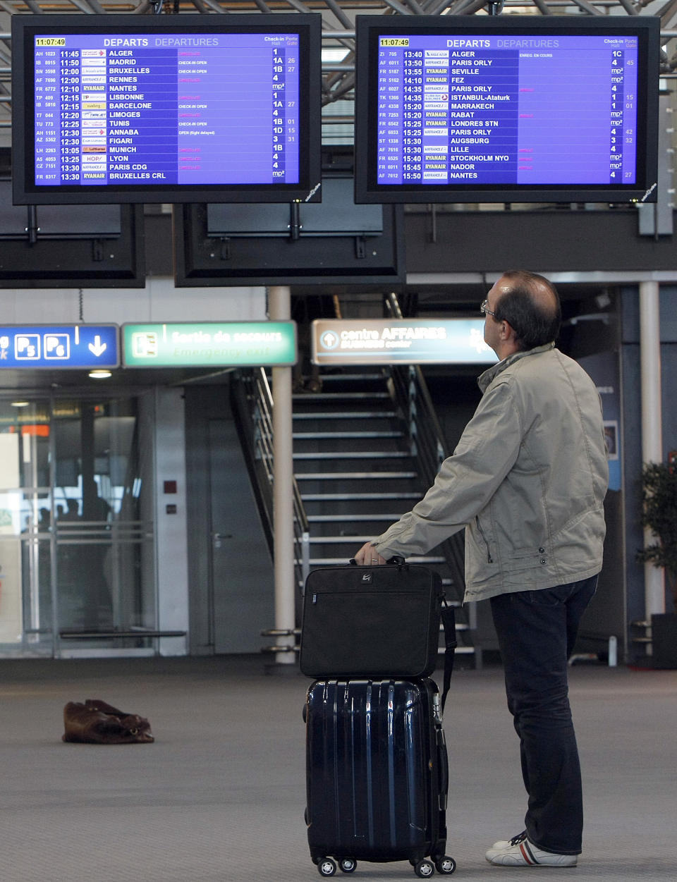 A passenger checks flight information at Marseille-Provence Airport, in Marignane, southern France, Tuesday, June 11, 2013. France's main airports have cut their flight timetables in half to cope with a three-day strike by air traffic controllers. The Civil Aviation Authority said that some 1,800 flights were cut Tuesday in France to protest against a plan to centralize control of Europe's air space. (AP Photo/ClaudeParis)