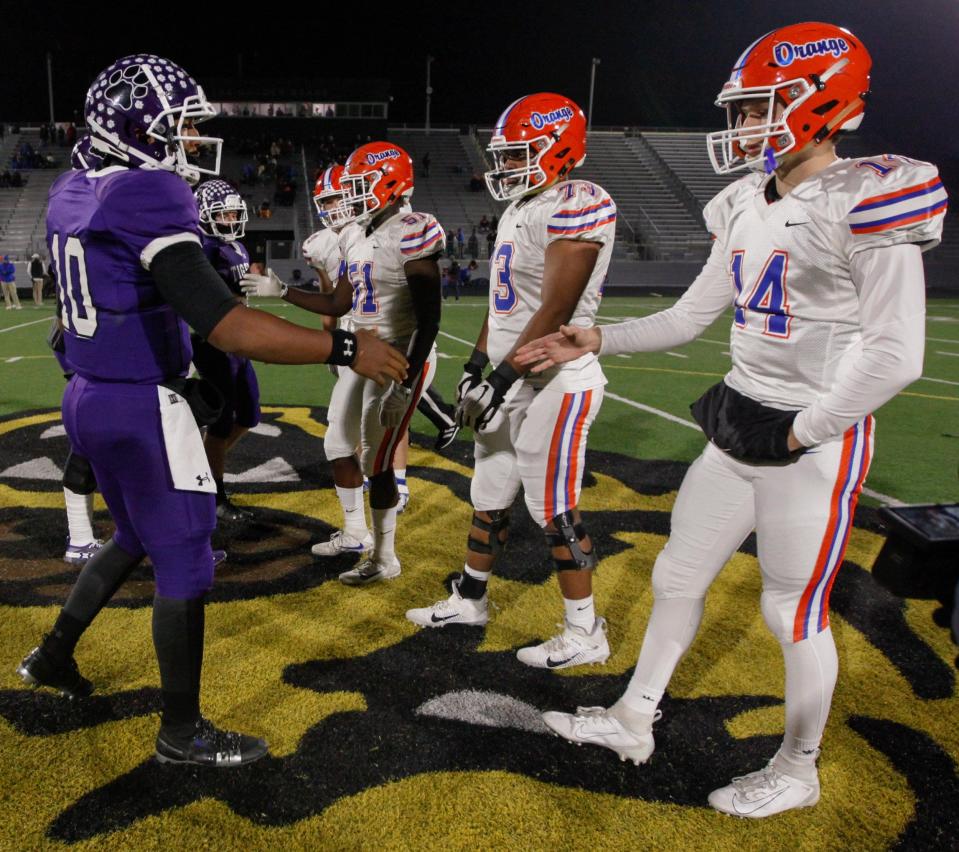 Pickerington Central quarterback Demeatric Crenshaw (10) and Olentangy Orange quarterback Spencer Hawkins shake hands after the coin toss before a regional semifinal game in 2019.