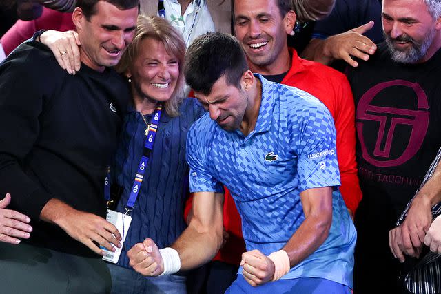 <p>MARTIN KEEP/AFP via Getty</p> Novak Djokovic celebrates with his mother, Dijana, after victory against Stefanos Tsitsipas during the Australian Open in January 2023.