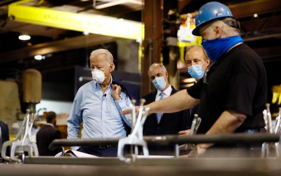 Democratic presidential candidate Joe Biden listens during a tour of a metal fabricating facility - AP Photo/Matt Slocum