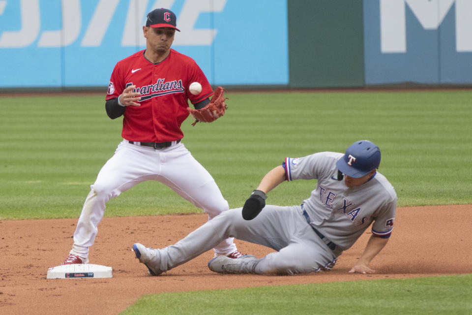 Cleveland Guardians' Andres Gimenez forces Texas Rangers' Corey Seager at second base during the first inning of the first game of a baseball doubleheader in Cleveland, Tuesday, June 7, 2022. (AP Photo/Phil Long)