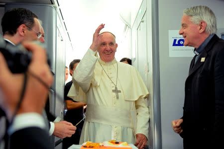 Pope Francis (C) waves next to newly-retired Father Federico Lombardi (R) during a press conference on a plane after the Pope's visit to Krakow, Poland for the World Youth Days, on July 31, 2016. REUTERS/Filippo Monteforte/Pool