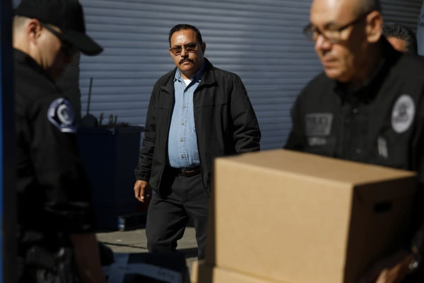 City of Maywood Mayor Ramon Medina keeps an eye on investigators with the Los Angeles County District Attorney's Office